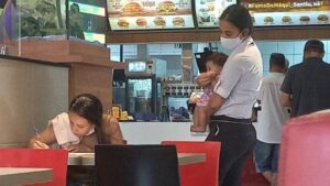 La manager di McDonald’s tiene in braccio il bambino mentre la madre compila la domanda di lavoro