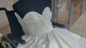 La vetrina di un negozio decide di esporre abiti da sposa con un manichino su una sedia a rotelle