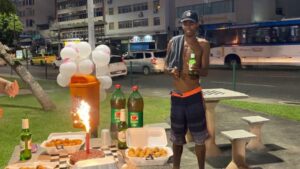 Gli amici organizzano una festa di compleanno con birre e torta per un giovane che vive per strada