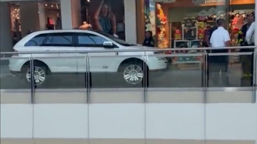 Una donna entra con la macchina all'interno di un centro commerciale